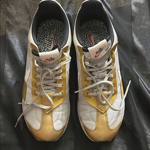 Nike White and Gold Sneakers with Iconic Swoosh